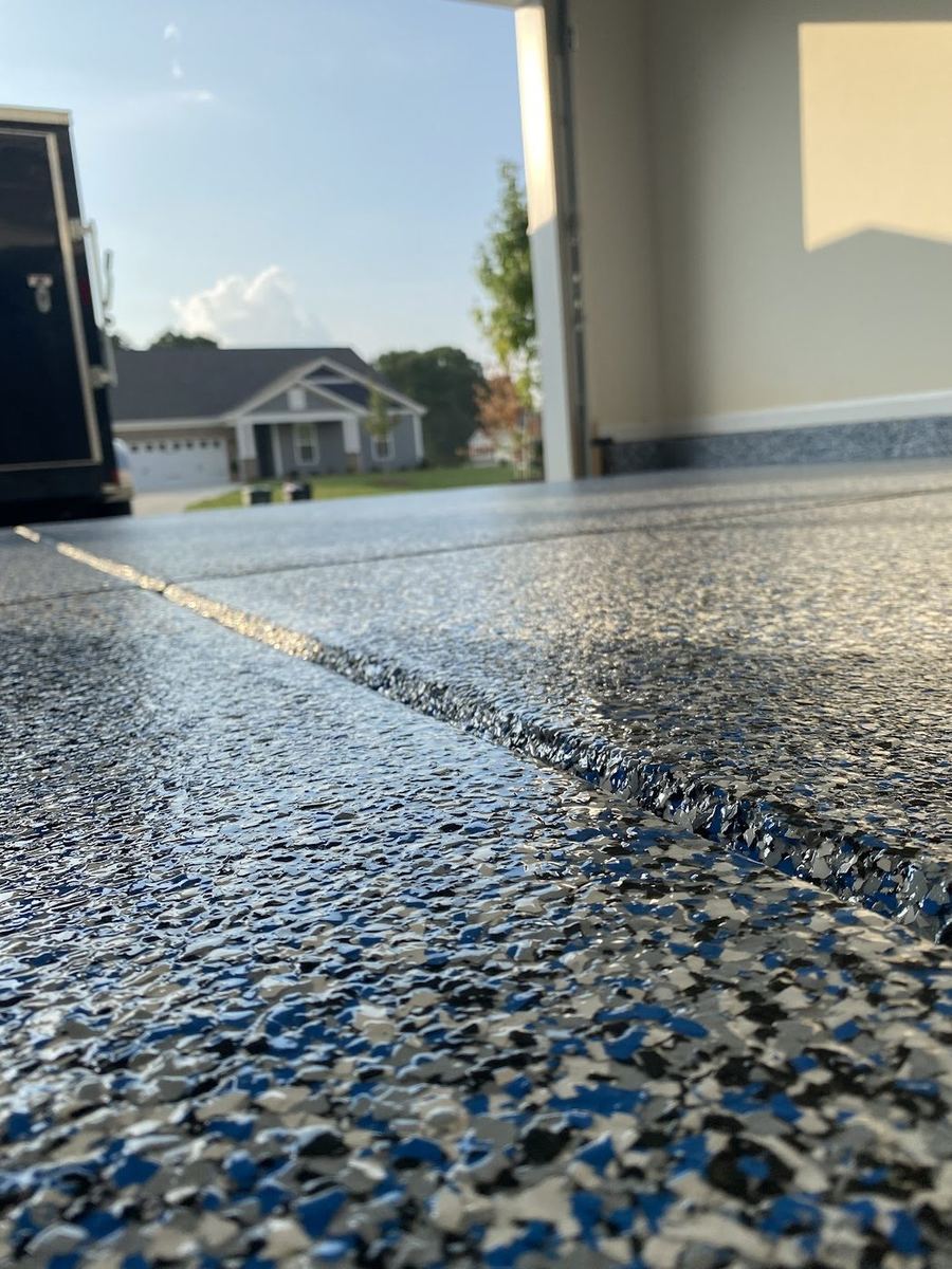 Finished blue and gray full-flake epoxy garage floor with the garage door open
