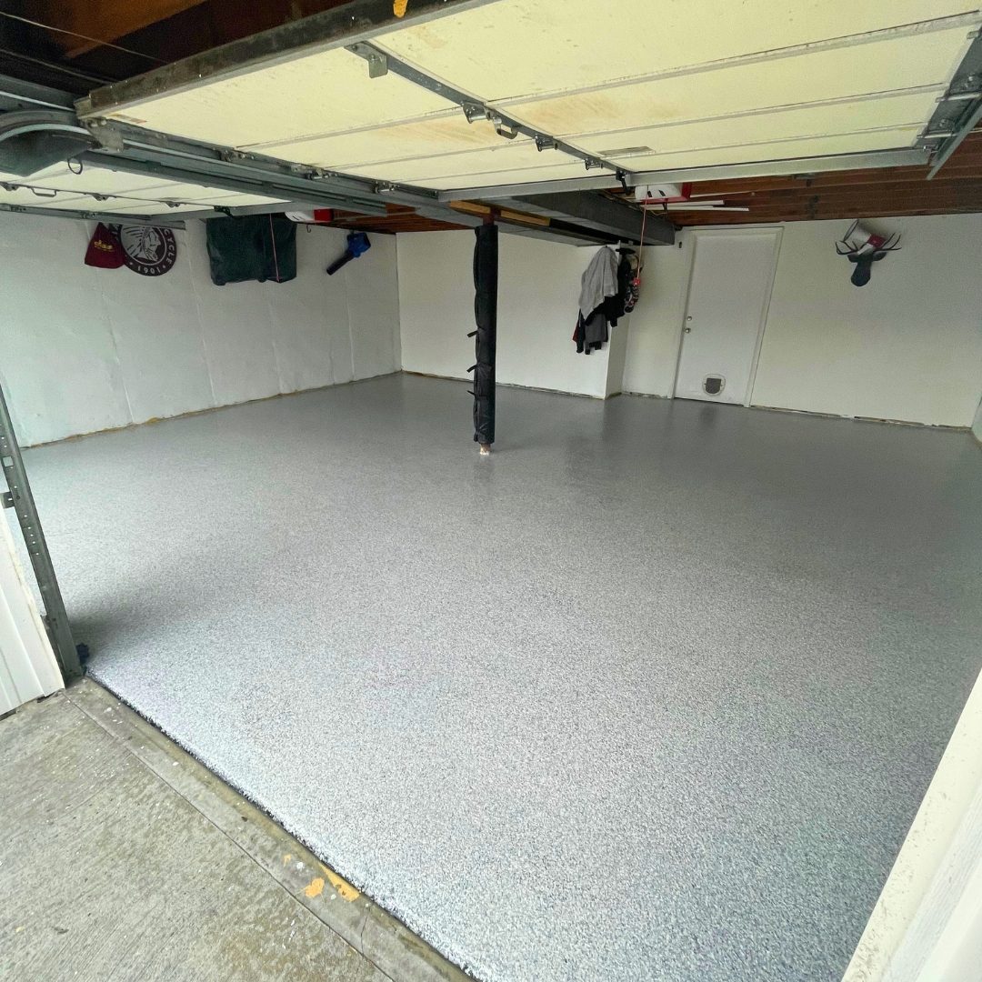 Finished gray and white flake epoxy garage floor in Kansas City, MO, wide view looking in from the open garage door