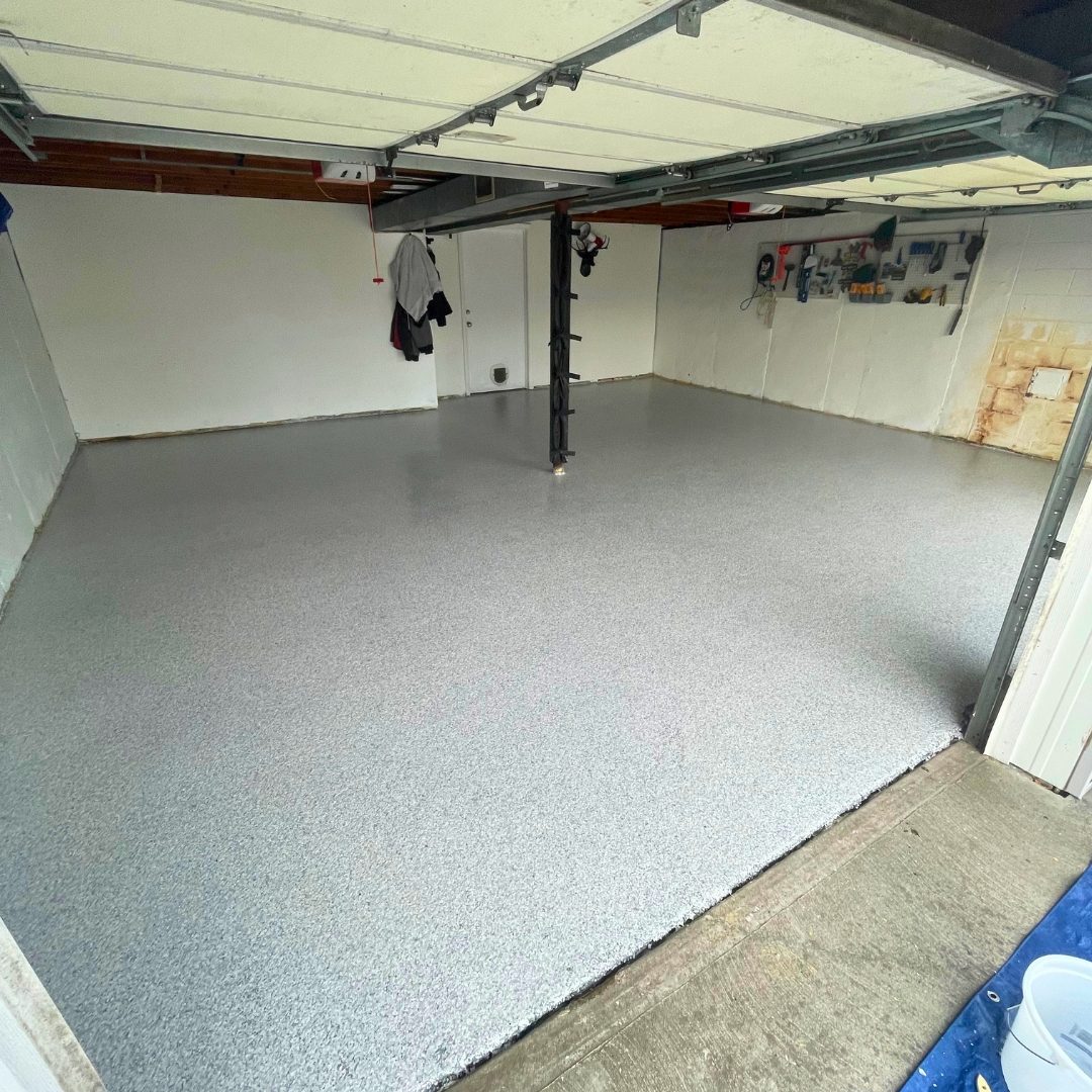 Finished gray and white full-flake epoxy garage floor in Kansas City, MO coated wall to wall across a two-car garage