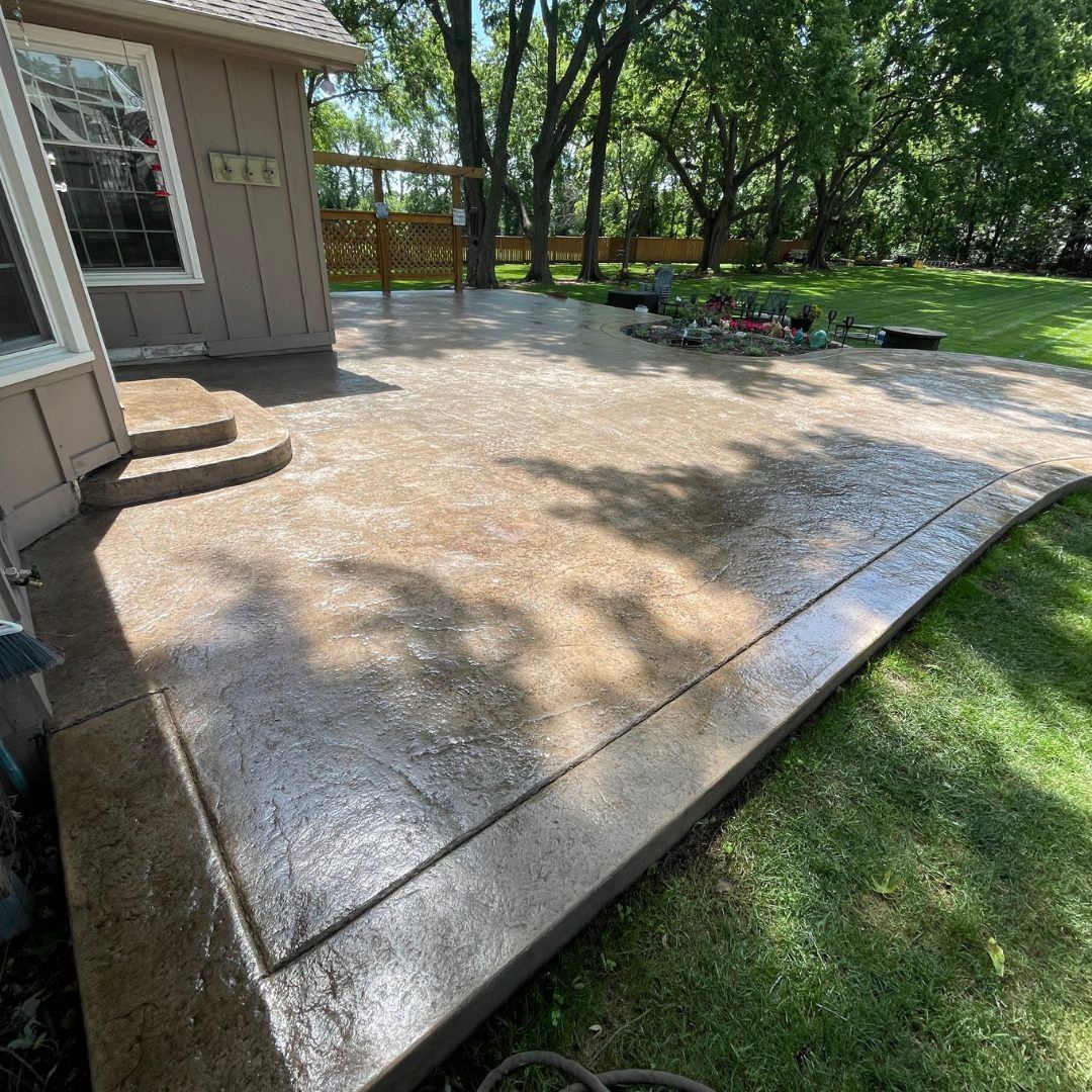 Finished stamped concrete patio in Stilwell, KS after washing and sealing, rich warm tones with a defined darker border