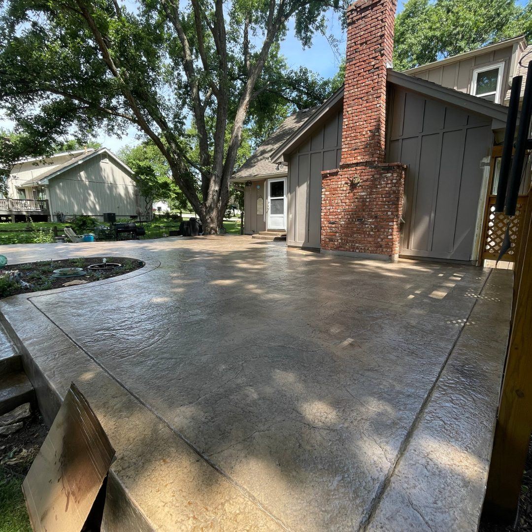 Finished stamped concrete patio in Stilwell, KS after washing and sealing, sealed surface with a deep, even color and protective wet-look finish